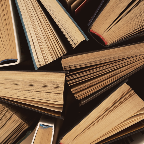 Stos starych książek widziany z bliska – widoczne grzbiety i kartki