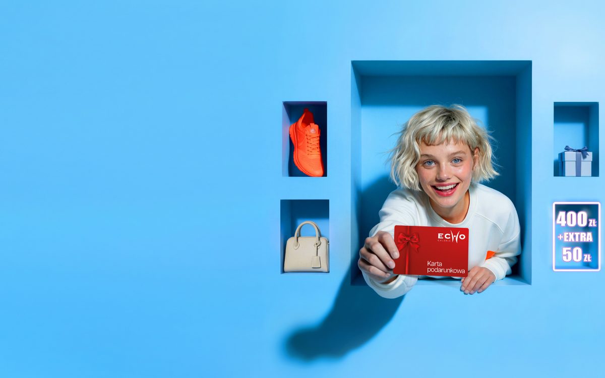 Uśmiechnięta kobieta z prezentami promująca akcję 50 zł bonusu do Karty Podarunkowej w Galerii Echo.