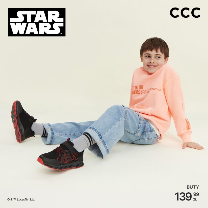 Grafika reklamowa sieci CCC przedstawia uśmiechnięte dziecko siedzące na jasnym tle w brzoskwiniowej bluzie i jeansach, eksponujące czarno-czerwone buty sportowe. W lewym górnym rogu widnieje logo marki Star Wars, a w prawym dolnym rogu umieszczono cenę obuwia wynoszącą 139,99 zł pod logotypem CCC.