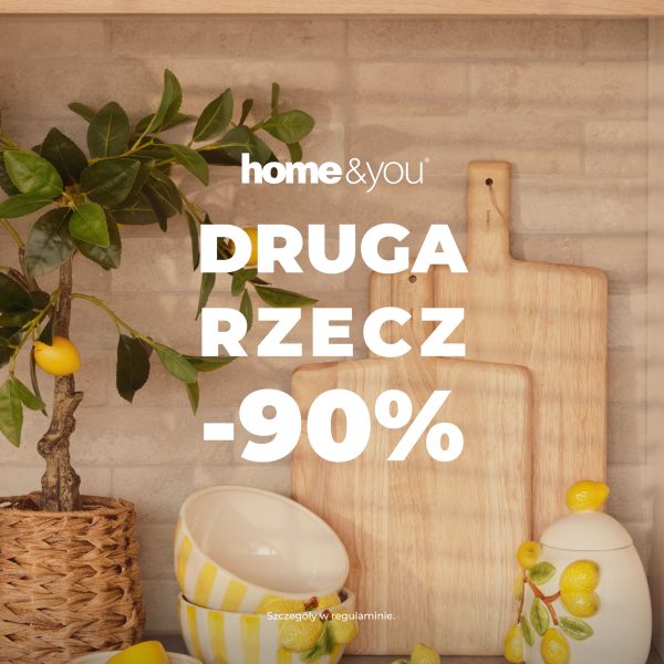 Grafika promocyjna sklepu home&you z hasłem „Druga rzecz -90%”. Na tle jasnej ceglanej ściany znajdują się drewniane deski do krojenia, dekoracyjna cytryna w donicy oraz ceramiczne naczynia z cytrynowym motywem.