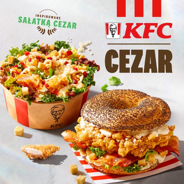 Plakat przedstawia apetyczne ujęcia sałatki i bajgla KFC umieszczone na jasnym tle obok dużego logotypu marki i napisu „CEZAR”. W górnym rogu widnieje hasło „Inspirowane sałatką Cezar”, a całość kompozycji uzupełniają luźno rozrzucone grzanki i kawałek panierowanego kurczaka.