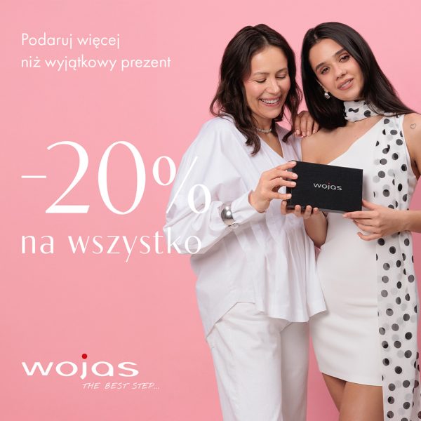 Kadr prezentuje elegancko ubraną kobietę siedzącą pośród dekoracji florystycznych i prezentującą skórzaną galanterię. Na jednolitym, jasnym tle po lewej stronie wyeksponowano hasło promocyjne z okazji Dnia Mamy wraz z wysokością zniżki i symbolem marki Wojas.