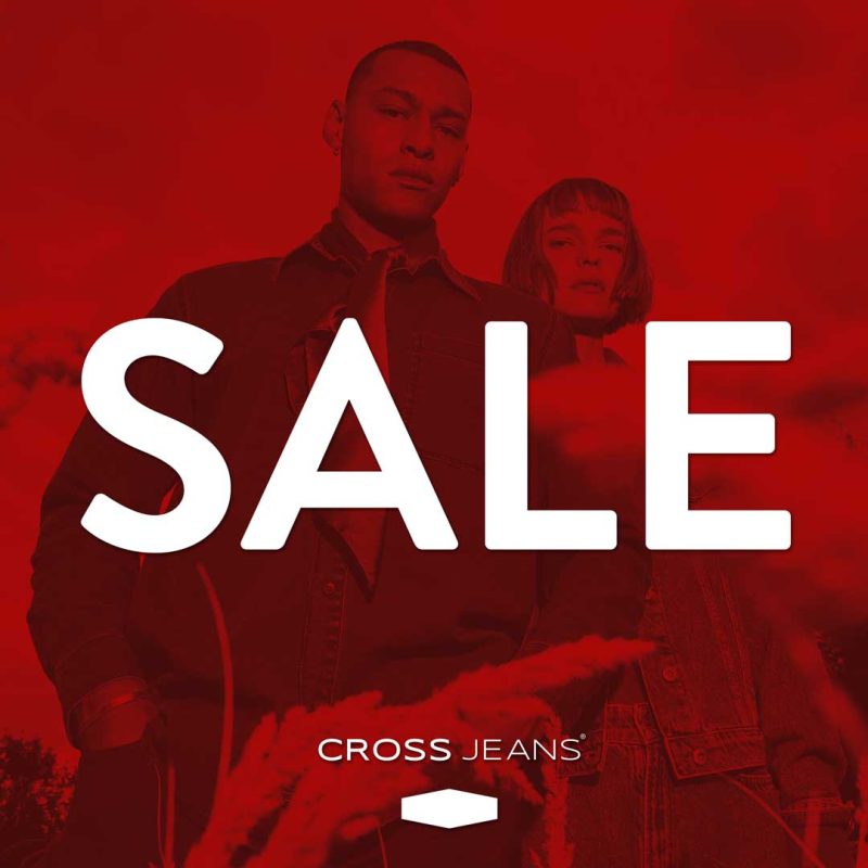 Plakat promocyjny marki Cross Jeans przedstawia kobietę i mężczyznę w dżinsowych ubraniach, sfotografowanych na tle nieba i pokrytych wyrazistą, czerwoną nakładką kolorystyczną. W centralnej części grafiki dominuje duży, biały napis „SALE”, a pod nim umieszczono minimalistyczne logo marki.