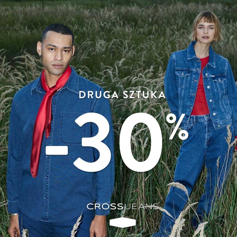 Plakat promocyjny marki Cross Jeans przedstawia kobietę i mężczyznę ubranych w jeansowe stylizacje z czerwonymi akcentami, stojących na tle wysokiej trawy. Na środku grafiki umieszczono duży biały napis informujący o zniżce 30% na drugą sztukę.