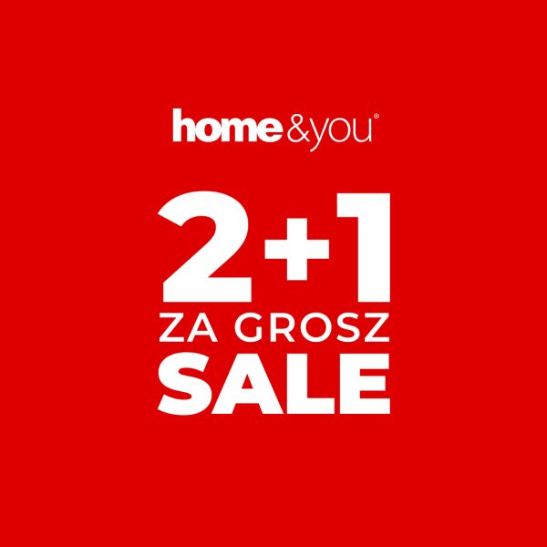 Czerwona plansza marketingowa prezentuje warunki wyprzedażowe sklepu z artykułami wyposażenia wnętrz. Napis „SALE” połączony z hasłem „2+1 ZA GROSZ” wskazuje, że przy zakupie dwóch produktów trzeci można otrzymać za symboliczną opłatą.