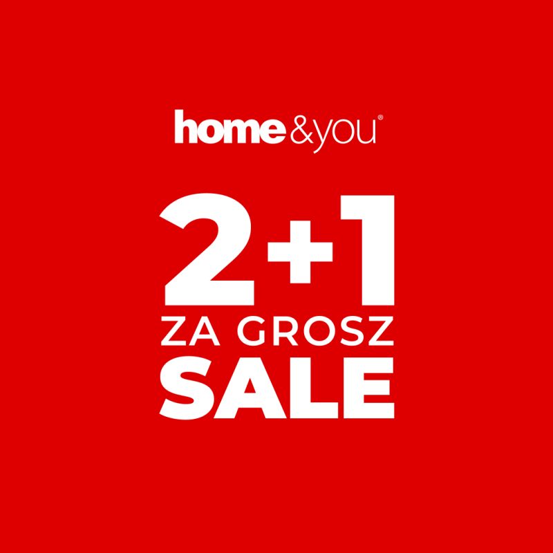 Czerwona plansza marketingowa prezentuje warunki wyprzedażowe sklepu z artykułami wyposażenia wnętrz. Napis „SALE” połączony z hasłem „2+1 ZA GROSZ” wskazuje, że przy zakupie dwóch produktów trzeci można otrzymać za symboliczną opłatą.