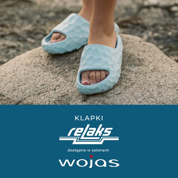 Plakat reklamowy marki Wojas prezentuje zbliżenie na letnie, piankowe klapki w kolorze jasnoniebieskim na tle kamienistego podłoża. Poniżej zdjęcia znajduje się estetyczny panel informacyjny z logotypami linii „relaks” oraz producenta.