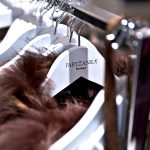 Zbliżenie na drewniany wieszak z wygrawerowanym logo Paryżanka Boutique.