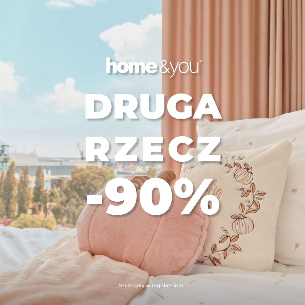 Kwadratowa grafika promocyjna marki home&you przedstawiająca przytulną sypialnię. Na łóżku z wzorzystą, jasną pośpielą leży różowy koc i dekoracyjne poduszki w kształcie dyni. W tle za łóżkiem okno z widokiem na miasto i beżowo-różowa zasłona. Na pierwszym planie białe logo home&you oraz duży biały napis DRUGA RZECZ -90%.