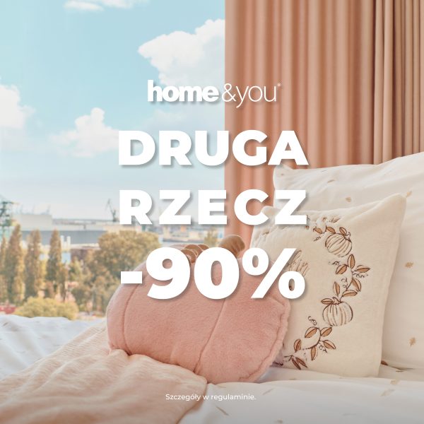 Kwadratowa grafika promocyjna marki home&you przedstawiająca przytulną sypialnię. Na łóżku z wzorzystą, jasną pośpielą leży różowy koc i dekoracyjne poduszki w kształcie dyni. W tle za łóżkiem okno z widokiem na miasto i beżowo-różowa zasłona. Na pierwszym planie białe logo home&you oraz duży biały napis DRUGA RZECZ -90%.