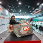 Kobieta pakująca pranie w nowoczesnym wnętrzu pralni Speed Queen w Galerii Echo.