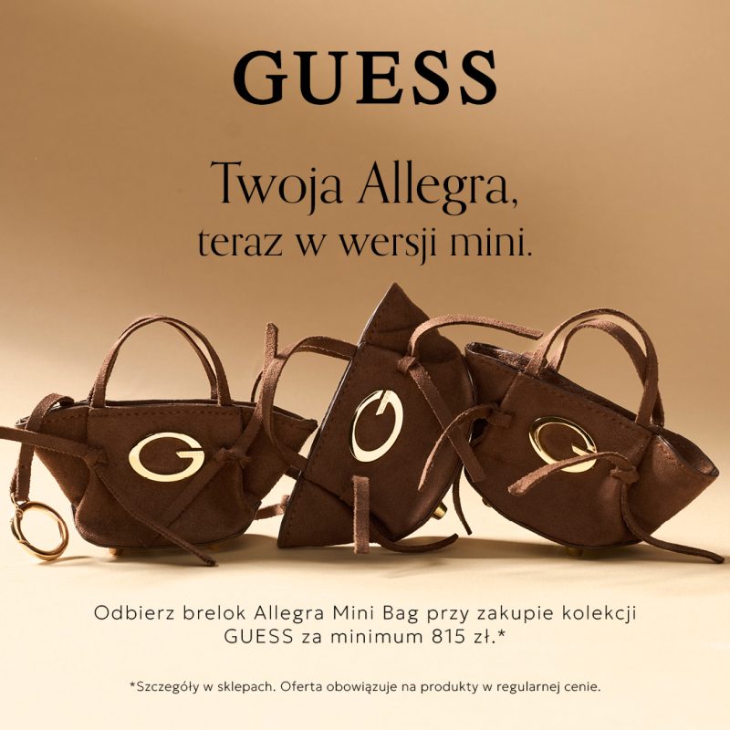 Kwadratowa grafika promocyjna marki GUESS na jasnym, beżowym tle. U góry umieszczono napis GUESS Twoja Allegra, teraz w wersji mini. W centrum znajdują się trzy zamszowe breloki w formie miniatur brązowych torebek ze złotym emblematem z literą G i złotym zapięciem. Na dole widnieje napis Odbierz brelok Allegra Mini Bag przy zakupie kolekcji GUESS za minimum 815 zł oraz adnotacja dotycząca szczegółów w sklepach.