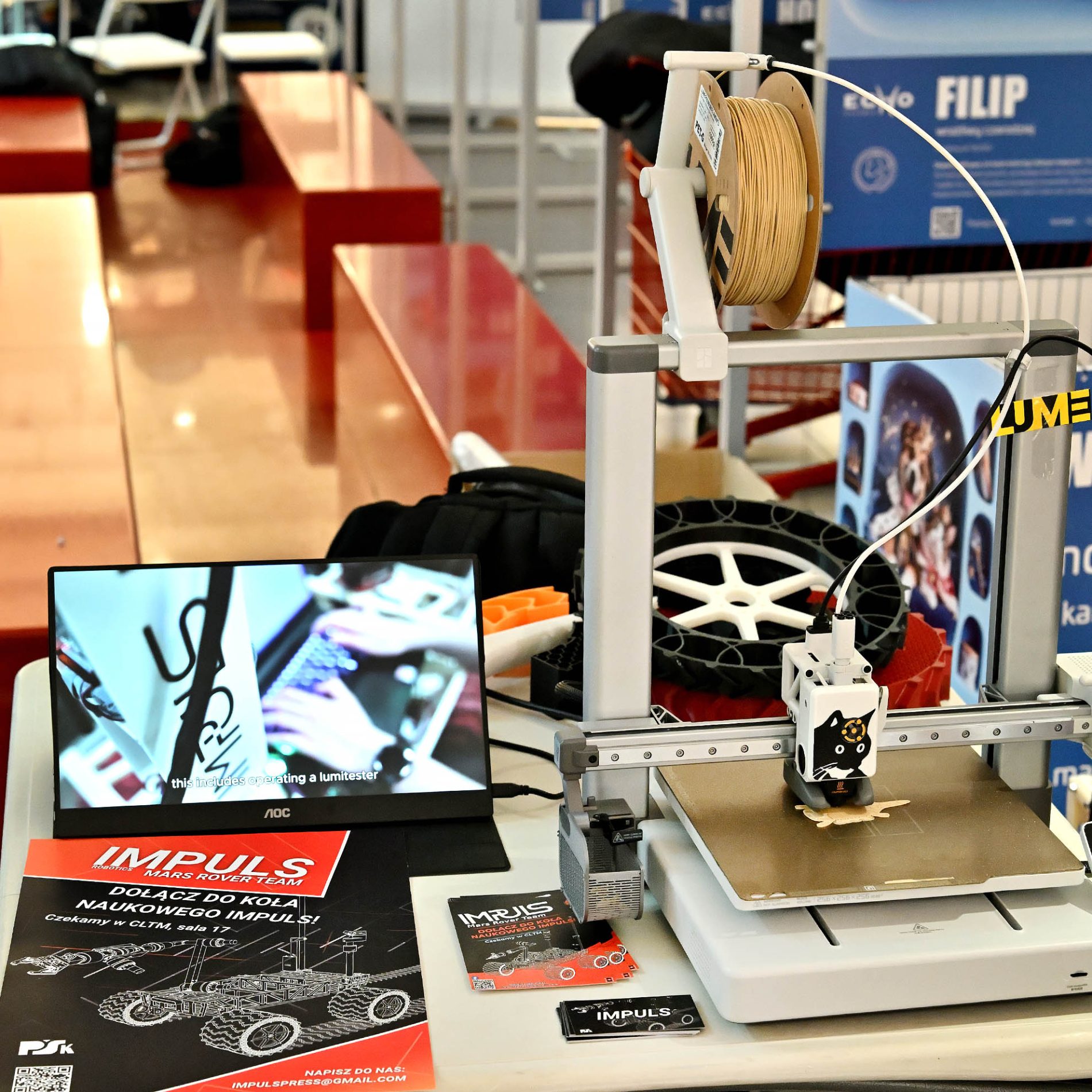 Drukarka 3D pracująca na stoisku koła naukowego Impuls podczas wydarzenia Echo Nauki.