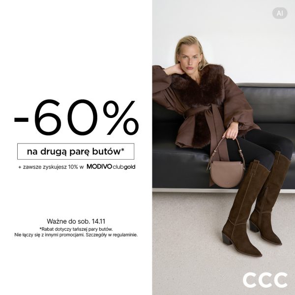 Blond modelka w brązowej kurtce z futrzanym kołnierzem i paskiem, w wysokich zamszowych kowbojkach w kolorze kawy, z beżową torebką, siedząca na skórzanej kanapie