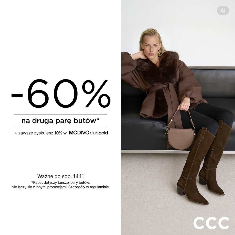 Blond modelka w brązowej kurtce z futrzanym kołnierzem i paskiem, w wysokich zamszowych kowbojkach w kolorze kawy, z beżową torebką, siedząca na skórzanej kanapie