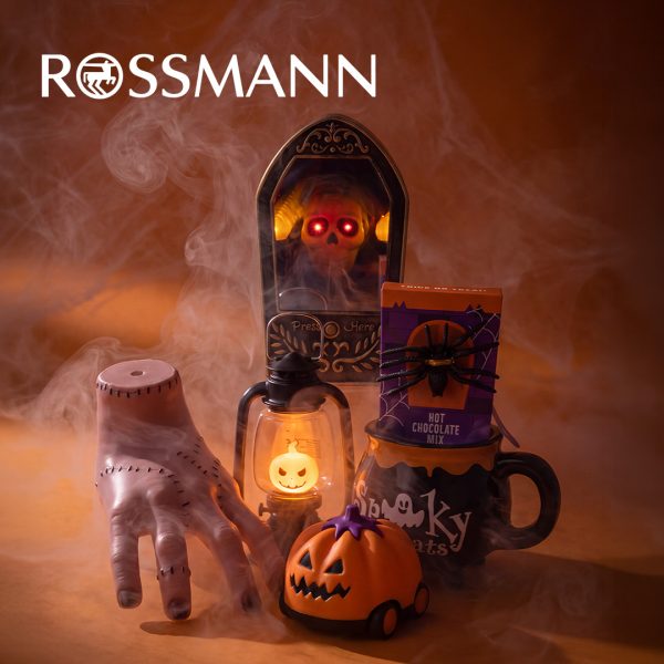 Dekoracje na Halloween obejmujące dynię na kółkach, lampion w kształcie duszka, kubek z gorącą czekoladą i sztuczną rękę w dymie z logo Rossmann w Galerii Echo w Kielcach